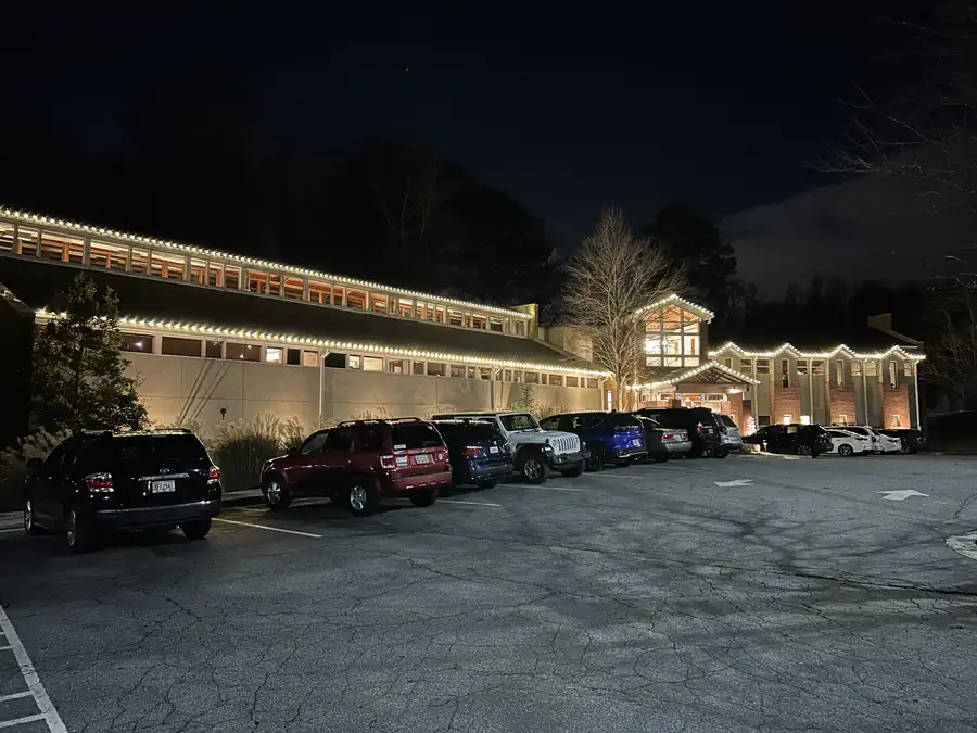 Large commercial property holiday lighting with illuminated rooflines and customer parking areas