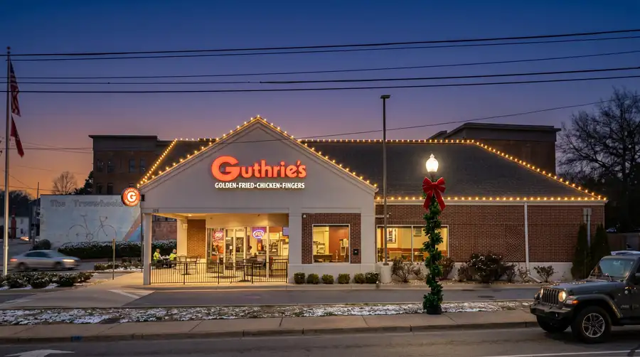 Restaurant holiday lighting with illuminated roofline, storefront windows and roadside visibility