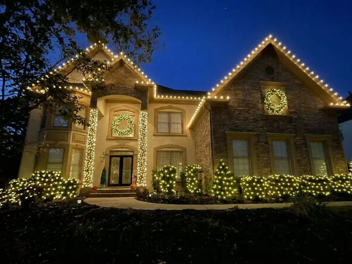 Detailed holiday home lighting with roofline lights, wreaths and illuminated front landscaping